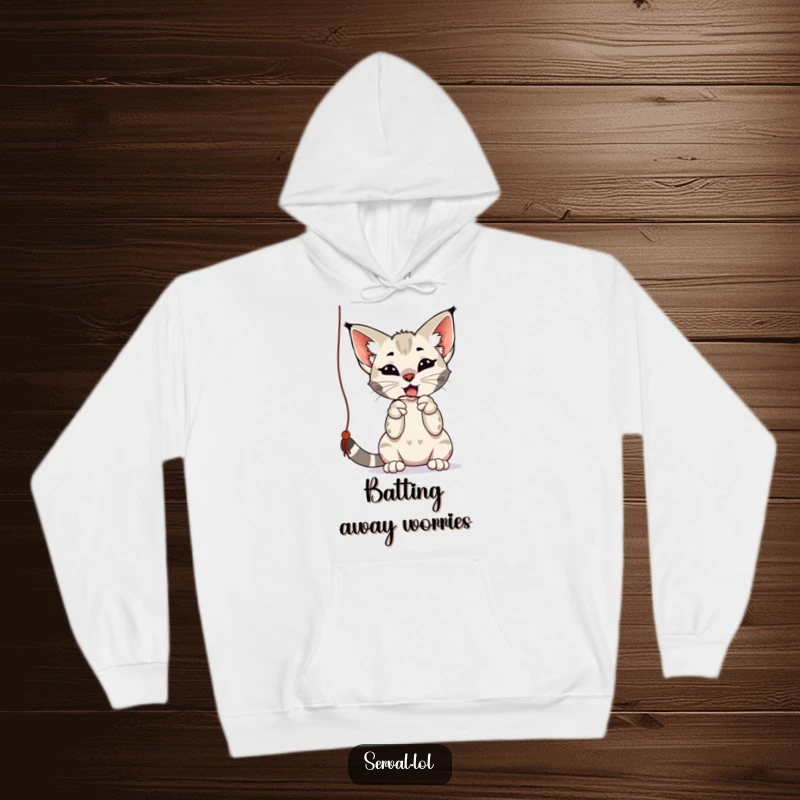 Funny serval hoodie featuring a playful serval batting at a dangling string with its paws, offering warmth and humor as a funny gift.