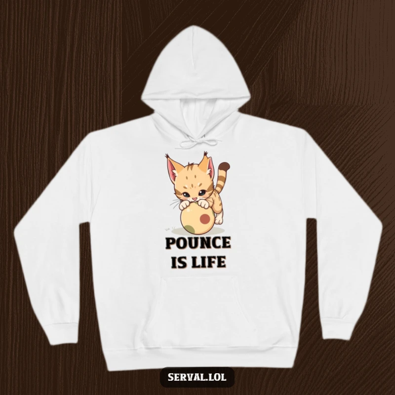 Funny Serval Pounce Hoodie. A serval cat is depicted in a powerful, playful pounce over a rolling ball, perfect for cozy, humorous moments.