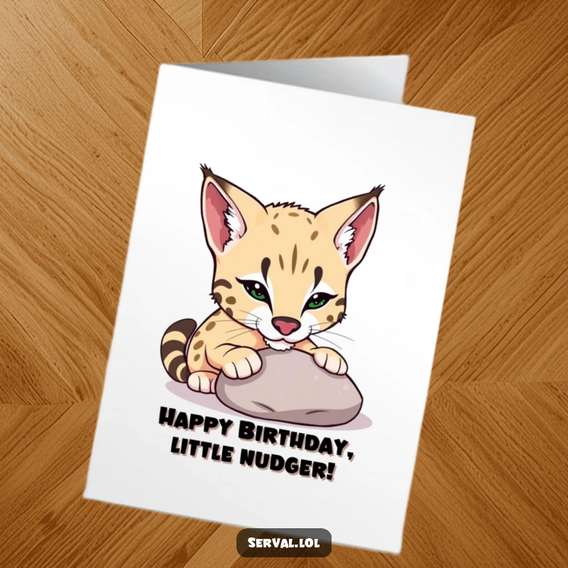 Free Printable Birthday Card showing a serval playfully nudging a smooth pebble with its cute nose in a curious manner.