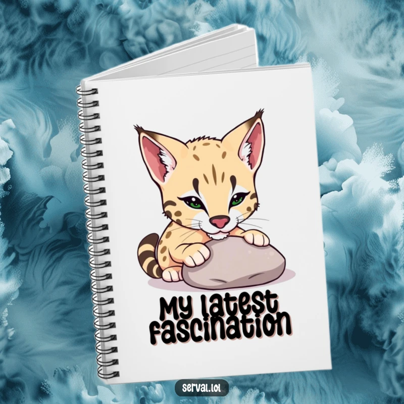Funny serval notebook showing a serval playfully nudging a smooth pebble with its nose, ideal for journaling and creative notes.