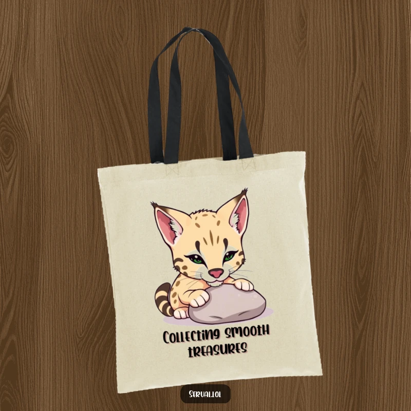 Funny serval tote bag with a serval playfully nudging a smooth pebble with its nose, a symbol of curiosity and lighthearted fun.